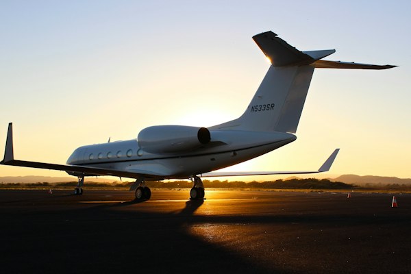 White private jet on a tarmac at golden hour