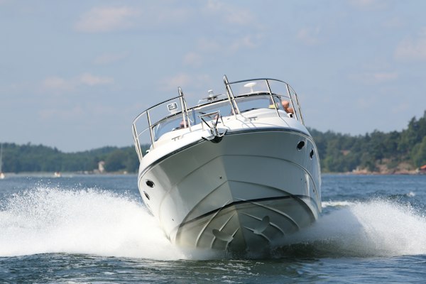 White cabin cruiser under way, bow on